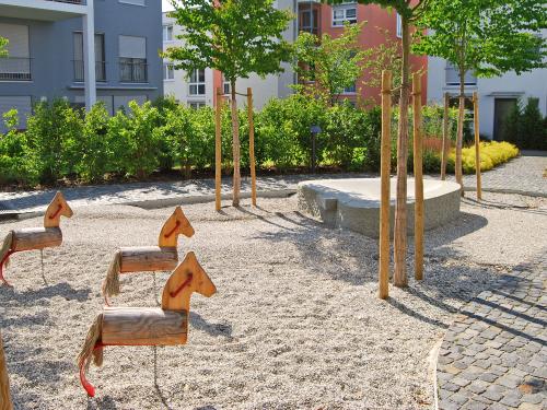 Playground with little wooden horses and trees