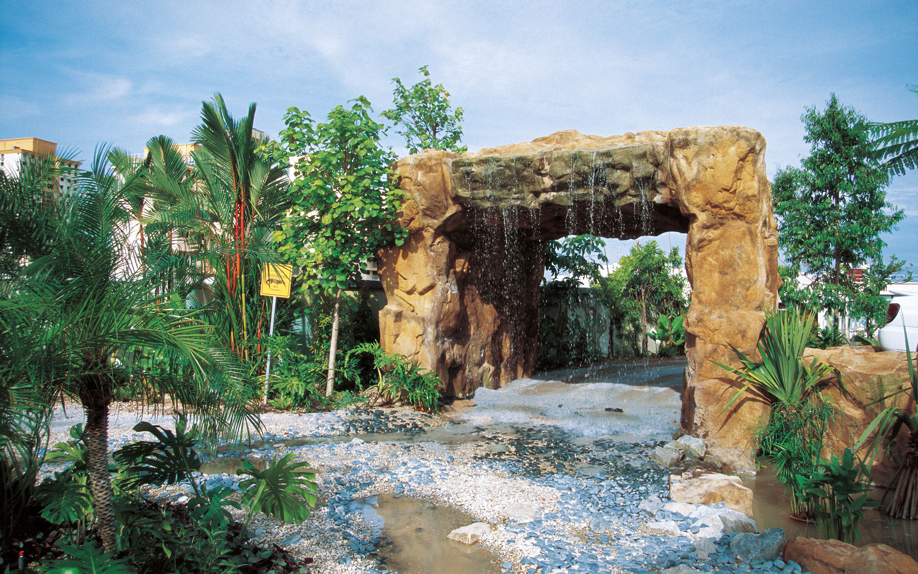 Archway with waterfall and tropical vegetation 
