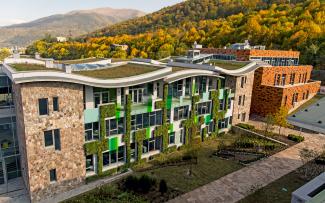 Building with natural stone façade, vertical greening and wavelike green roofs